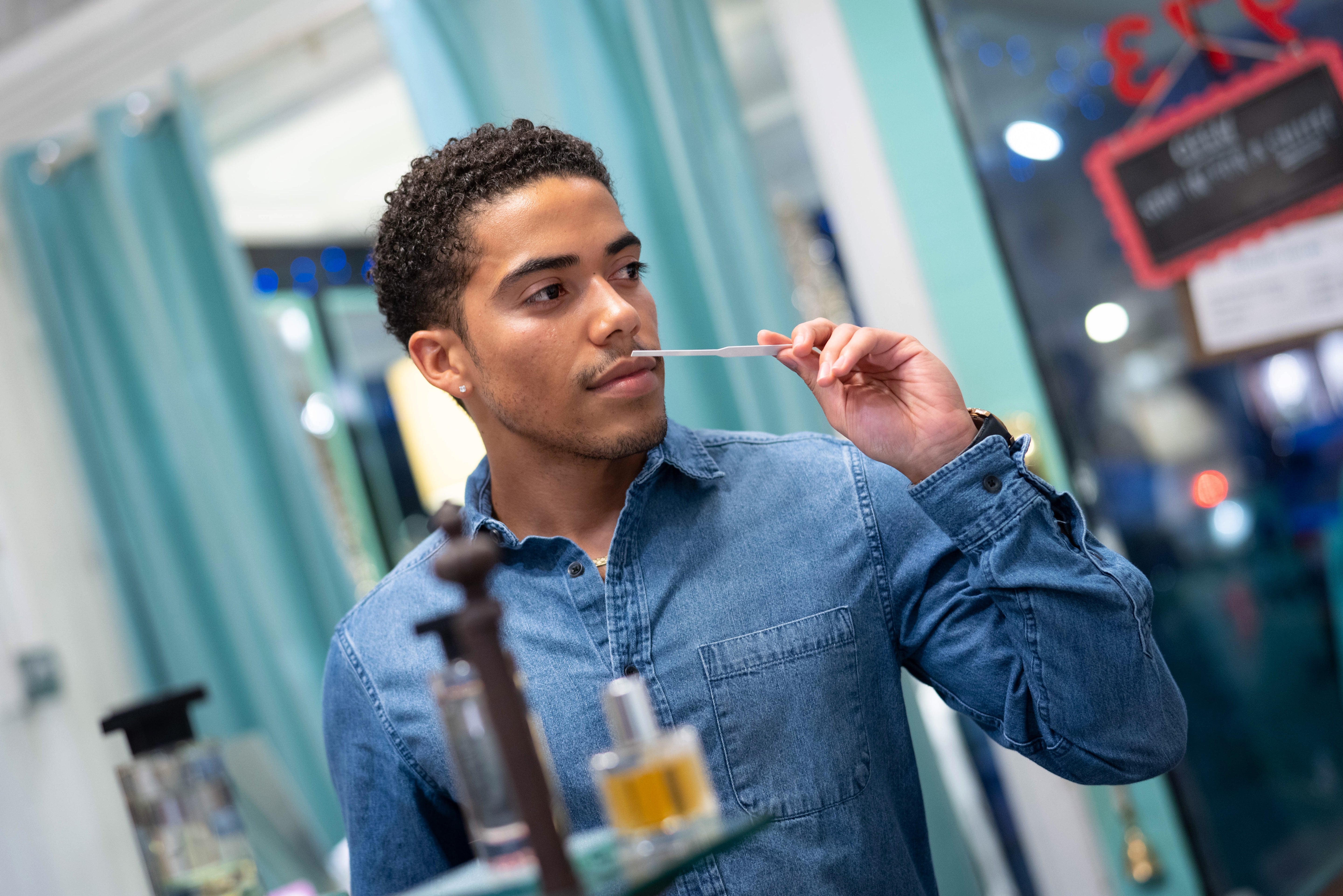Racially ambiguous man smelling a scent strip