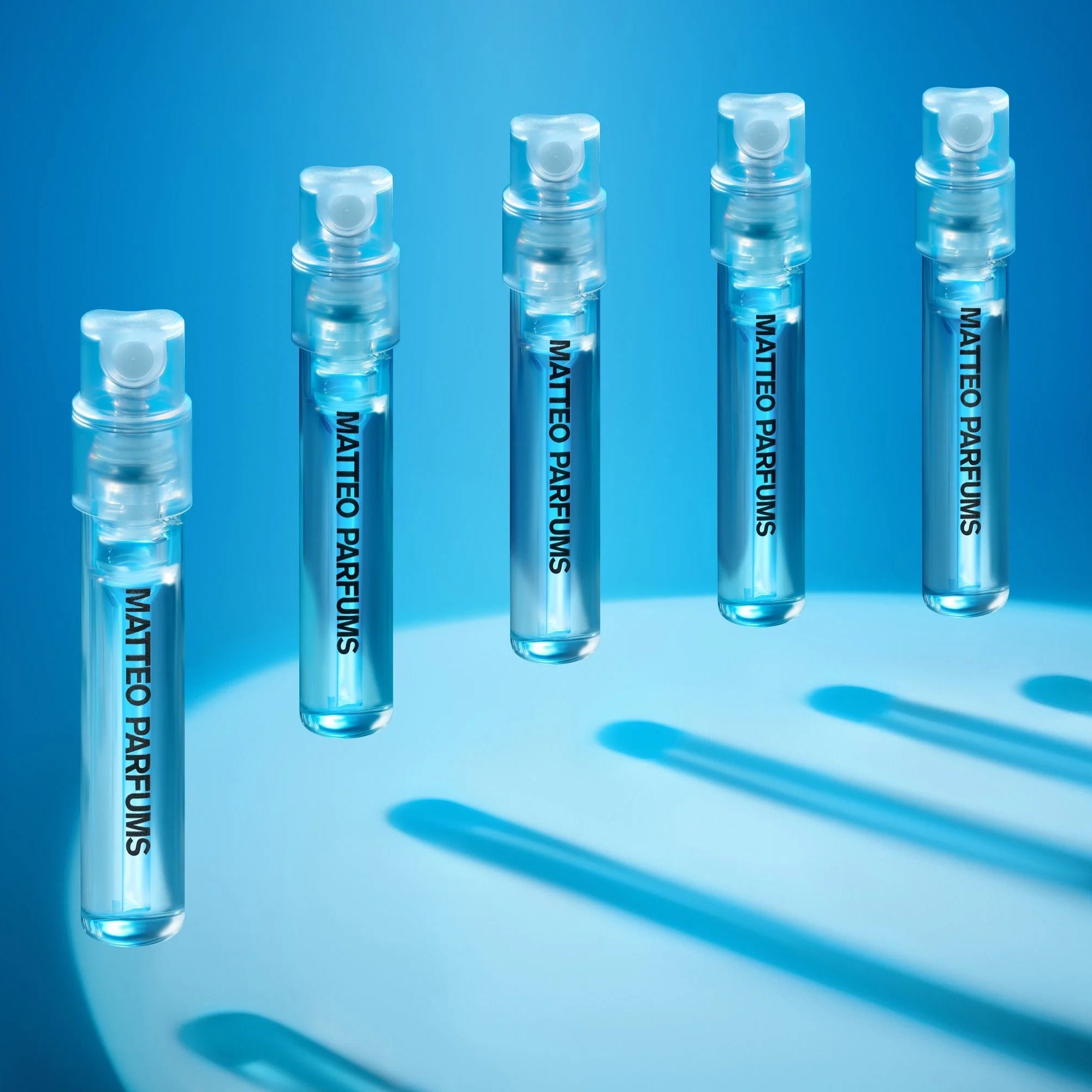 Set of MATTEO PARFUMS fragrance samples floating on a blue background with a spotlight